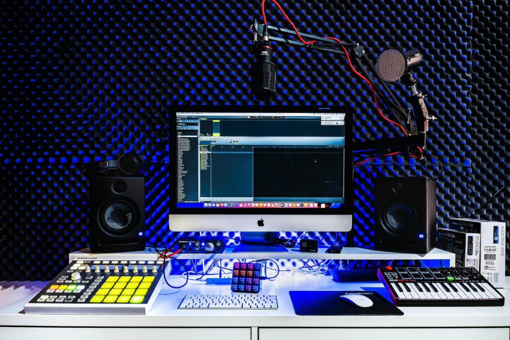 A contemporary music studio setup featuring a computer, speakers, and audio equipment.