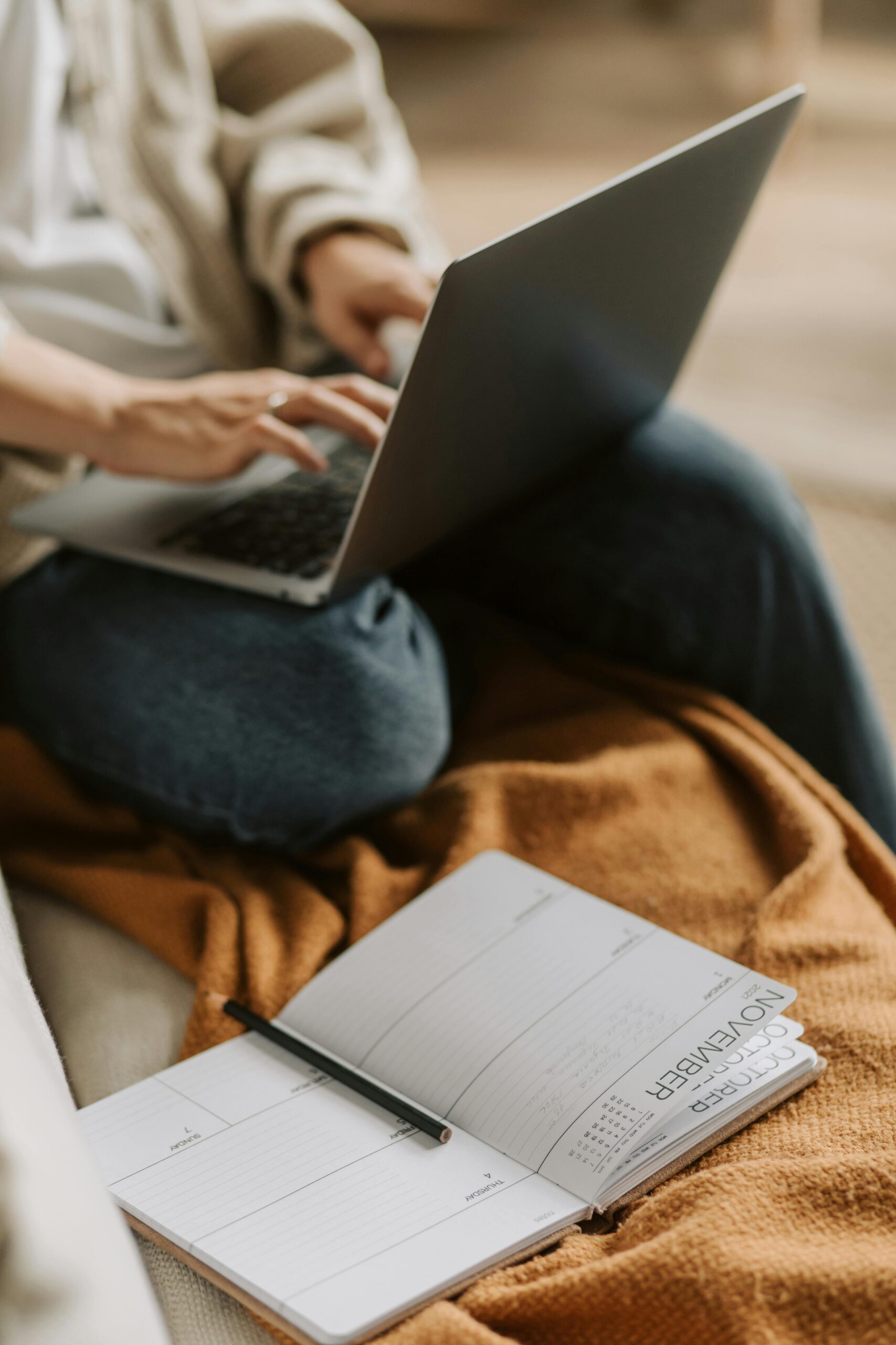 Cozy work setup with a laptop and planner for productive remote work experience.